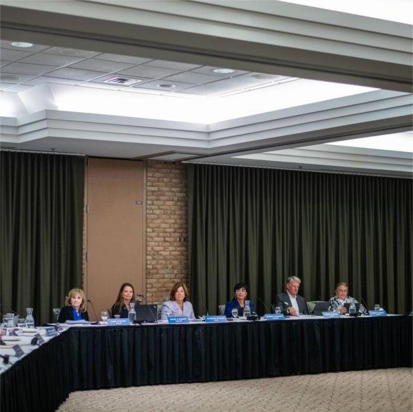 People sit at a table during a meeting.