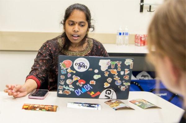 student talking with laptop open in front of her