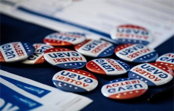 Several buttons that read "GVSU Votes!" on a table. 