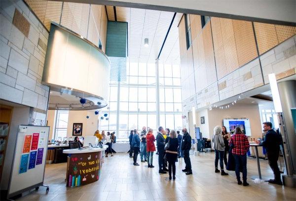 people mingle in the atrium of the Mary Idema Pew Library